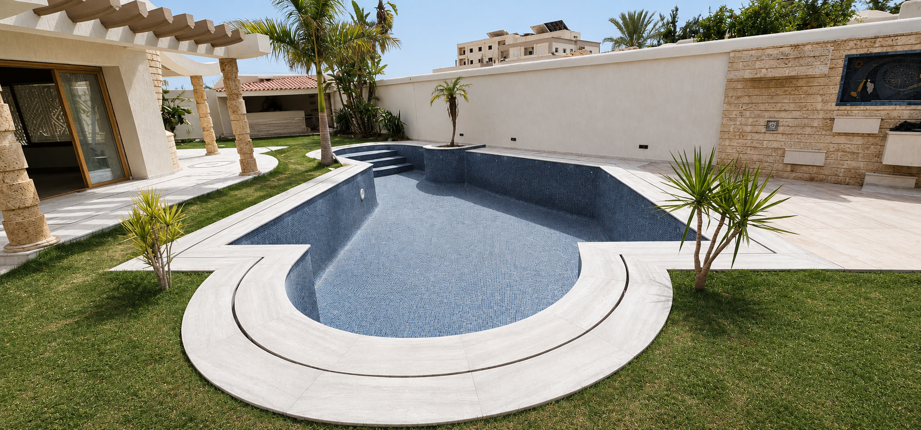 Piscine TCDC revêtue de mosaïque et entourée de margelles claires